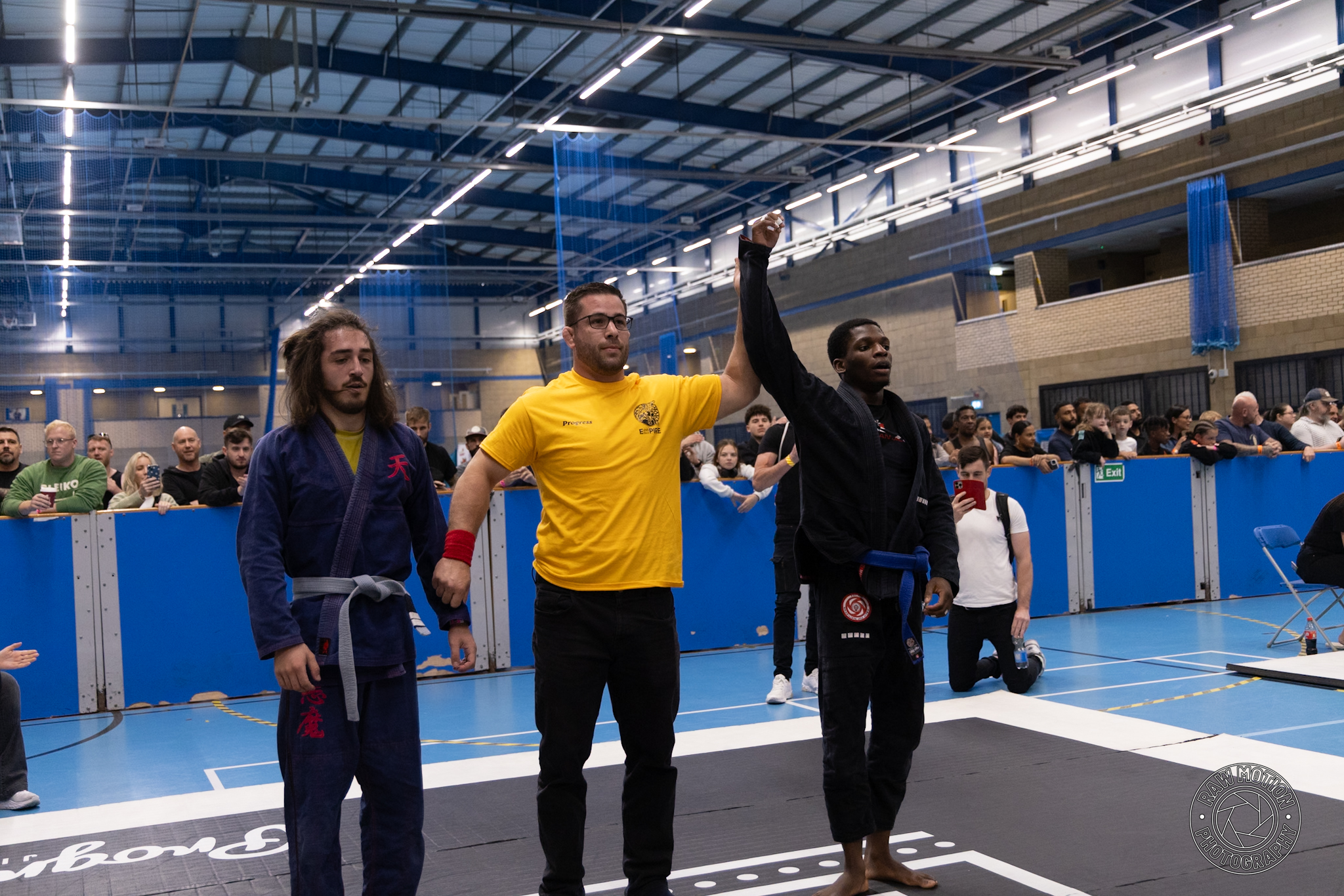 Sheyin at a Brazilian Jiu-Jitsu competition with his hand raised after a match